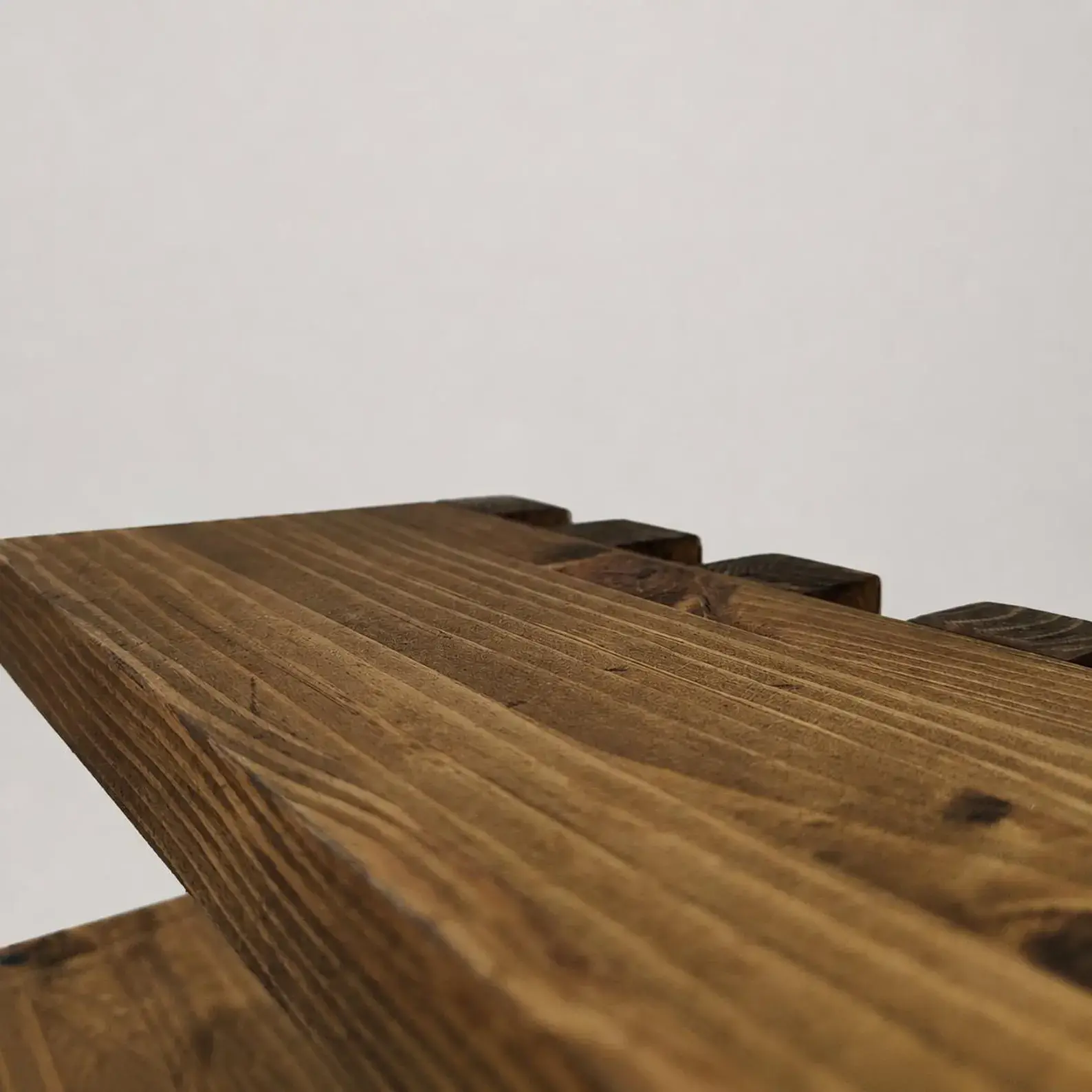 Close-up of warm brown stain and natural pine grain on the shelf
