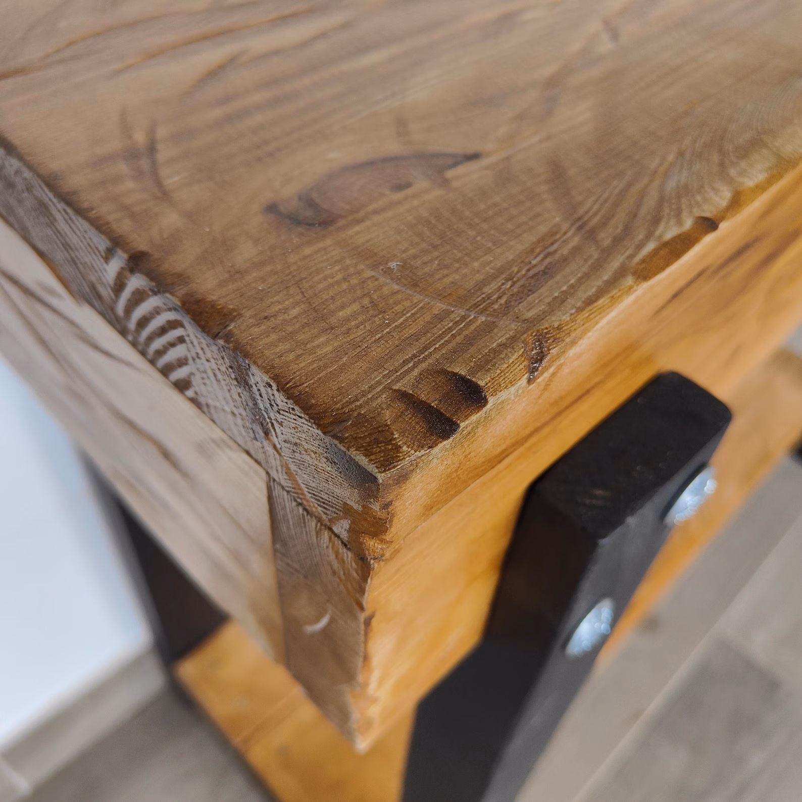 Close-up of the solid pine corner joint and dark-stained wooden leg