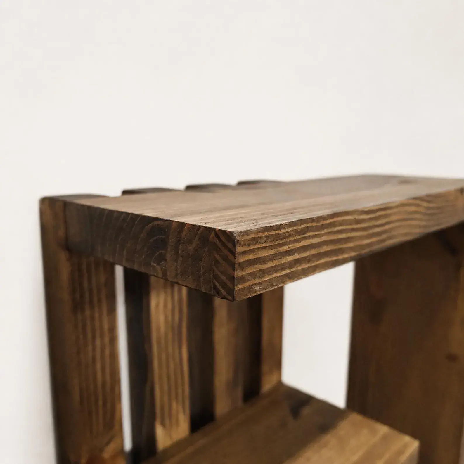 Geometric pine wall shelf construction with horizontal tiers and vertical slats