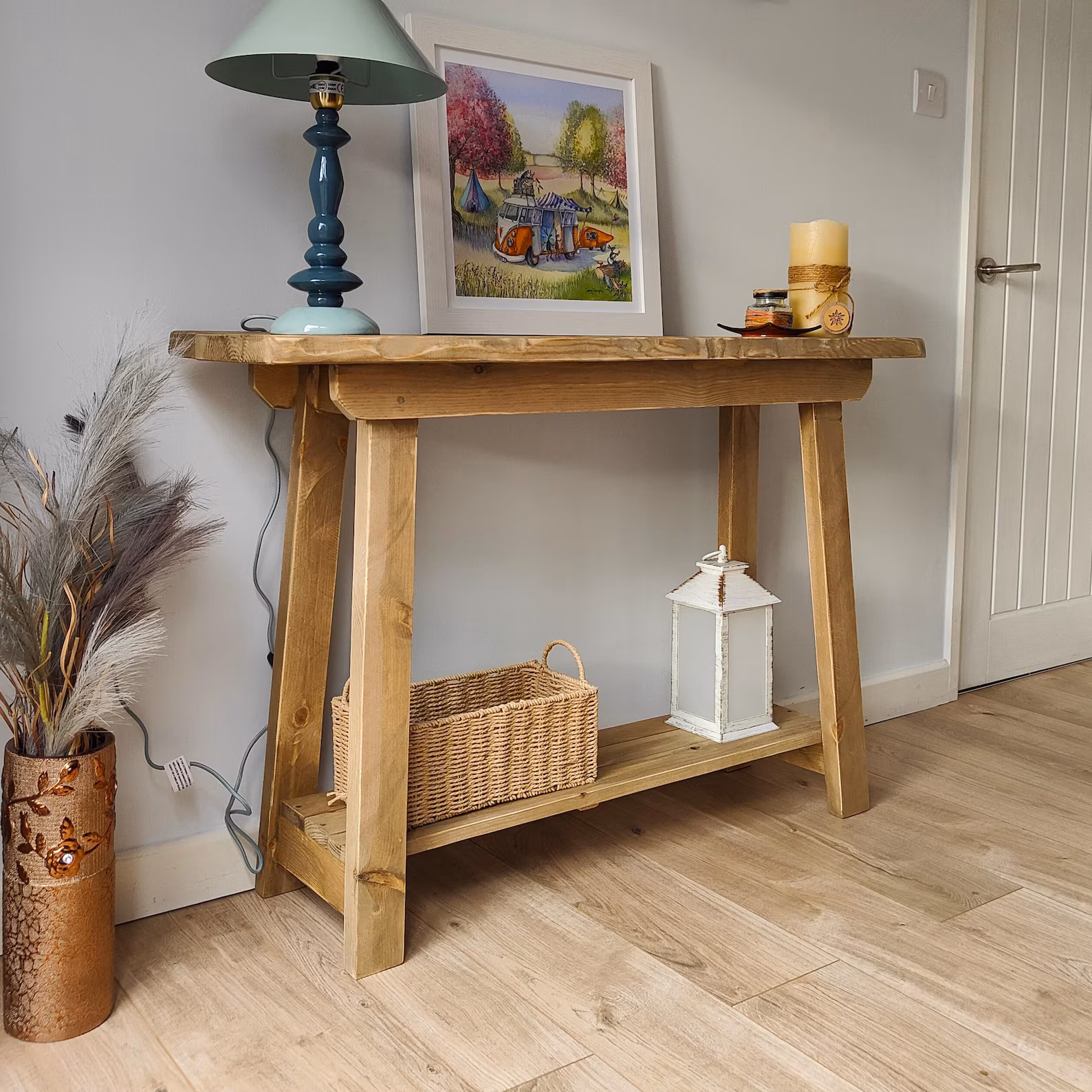 Light solid pine console table with lower storage shelf and home decor