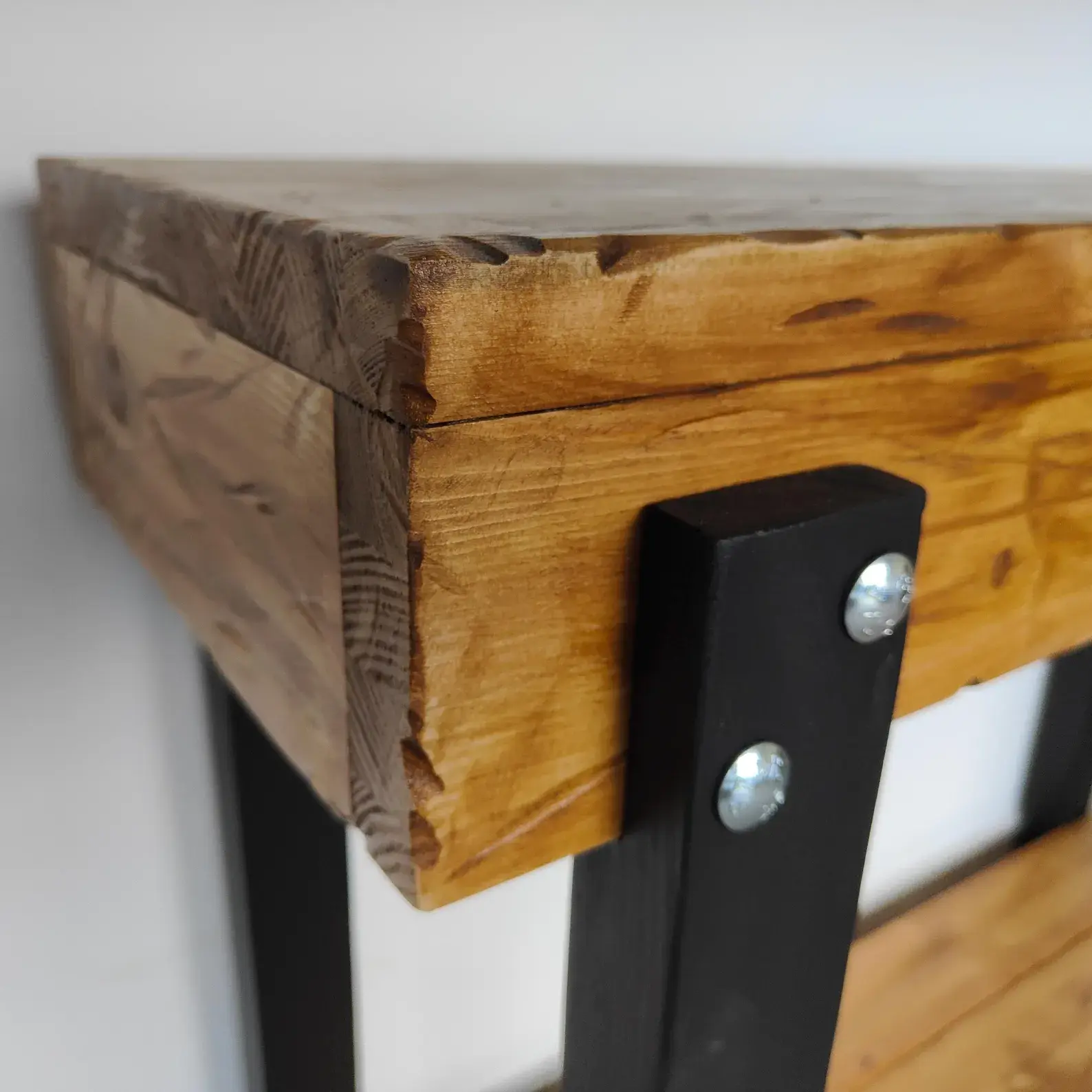 Lower pine shelf supported by dark-stained solid wood legs