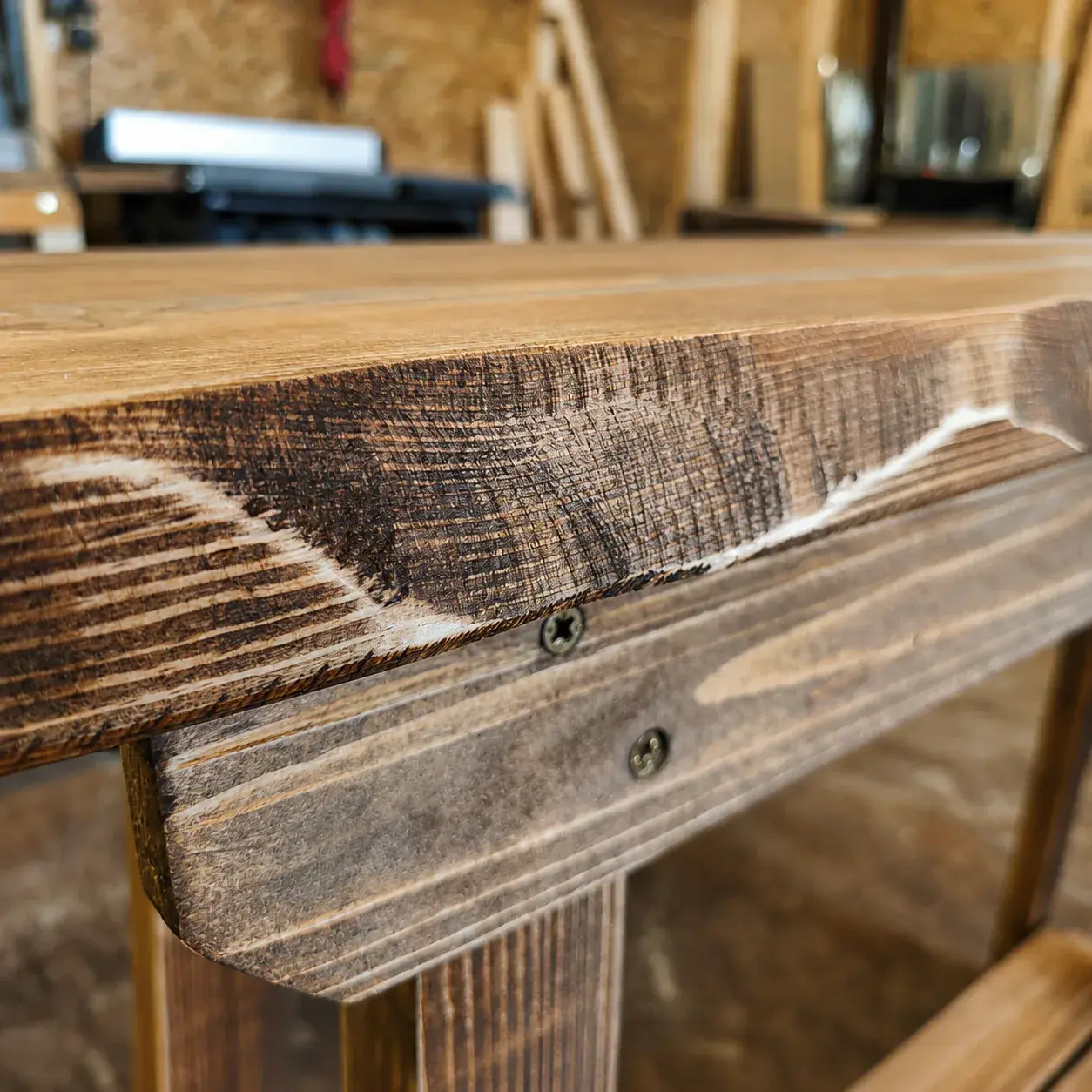 Close-up of a handcrafted solid wood edge showing natural grain, irregularity and visible tool marks